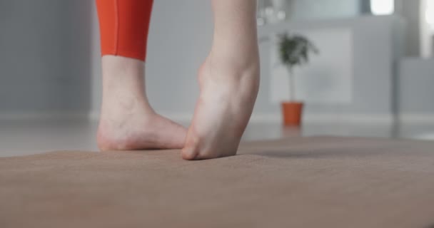 Frau wärmt sich auf und streckt ihre Füße beim Yoga-Kurs in Zeitlupe, Person macht körperliche Übungen, Stretching und Gymnastik, 4k DCI 60p Prores HQ — Stockvideo