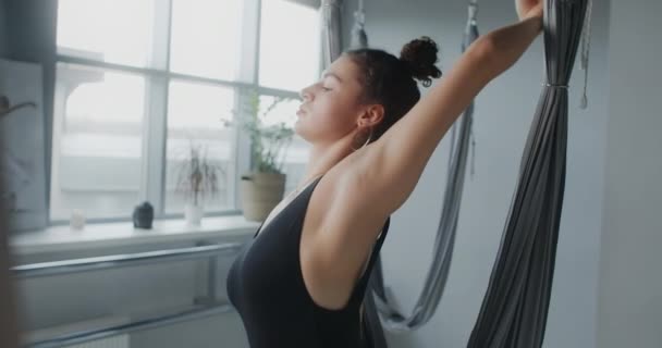 Привлекательная молодая женщина растягивает себя в студии йоги мухи, йоги классов в замедленной съемке, человек делает физические упражнения, растяжения и гимнастики, 4k DCI 60p Прорес HQ — стоковое видео