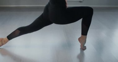 Çekici genç kadın sinekle yoga hamağını yavaş çekimde geriyor, esnek kadın akrobatik ve plastik egzersizler yapıyor, yoga ve esneme, 4k DCI 60p Prores 422