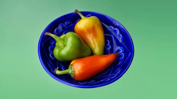 Three Peppers Blue Plate Mint Background — Stock Photo, Image