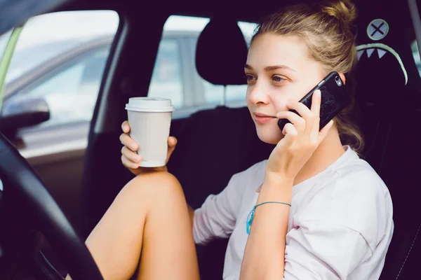 Дівчина з телефоном в машині — стокове фото