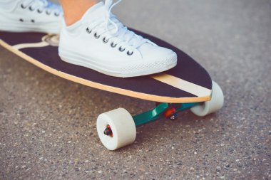 genç kadın sokakta longboard, kaykay, hippi tarzı, açık ile poz kapat portre, spor ayakkabı, kot kot pantolon.