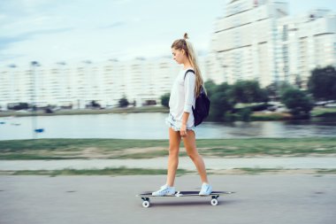 genç kadın sokakta longboard, kaykay, hippi tarzı, açık ile poz kapat portre, spor ayakkabı, kot kot pantolon.