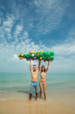 Çift balon ağaç kumsalda holding