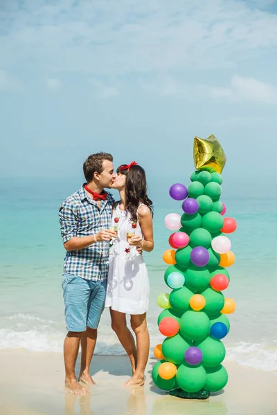 Pareja de pie cerca de globo árbol en la playa — Foto de Stock