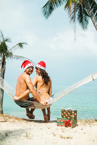 Couple sitting in hammock on beach — Stock Photo, Image