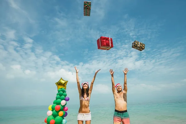 Paar gooien geschenkdozen op strand — Stockfoto