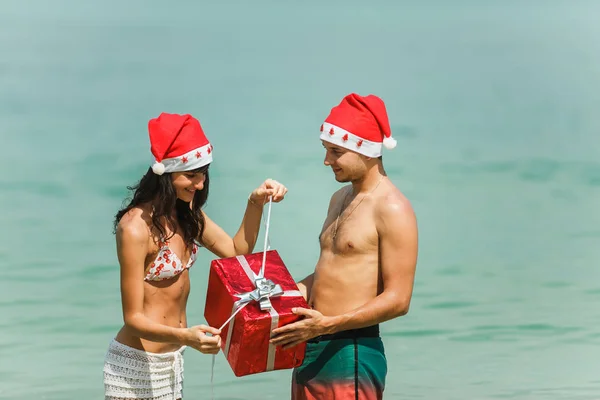 Pareja de pie con caja de regalo en la playa — Foto de Stock