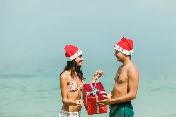 Pareja de pie con caja de regalo en agua — Foto de Stock