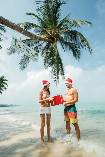 Pareja de pie con caja de regalo en la playa —  Fotos de Stock