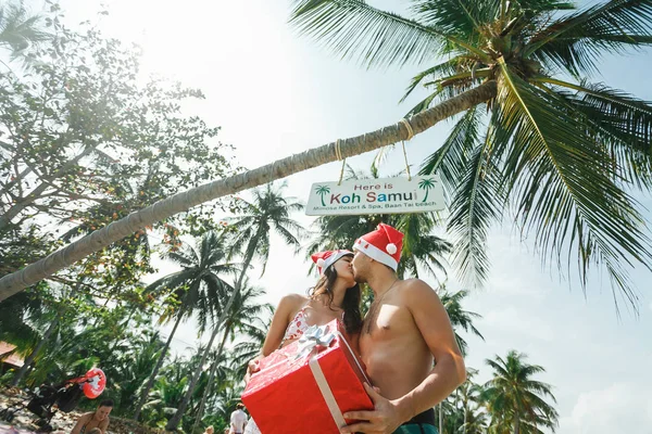 Pareja de pie con caja de regalo en la playa —  Fotos de Stock