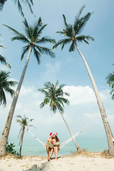 Pareja sentada en hamaca en la playa —  Fotos de Stock