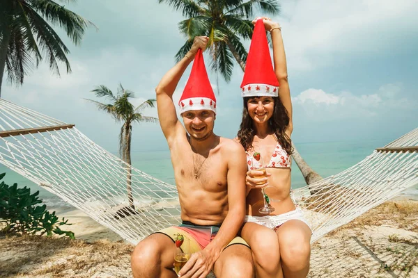 Couple sitting in hammock on beach — Stock Photo, Image