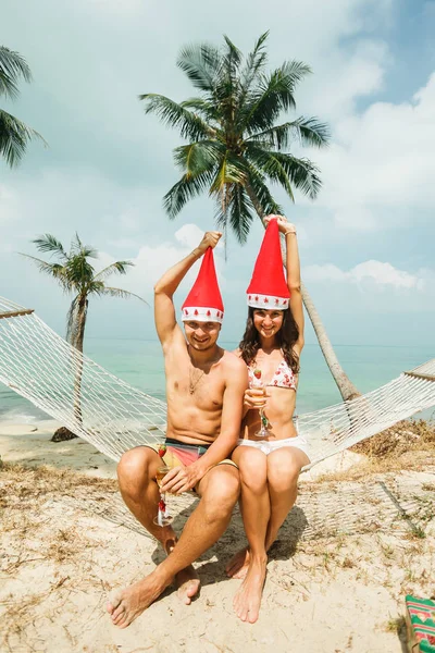 Couple sitting in hammock on beach — Stock Photo, Image