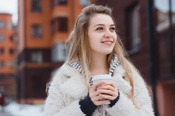 Молодая девушка позирует на улице, пьет кофе. — стоковое фото