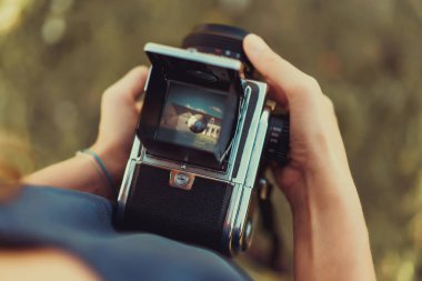 Woman hands holding vintage photo camera clipart