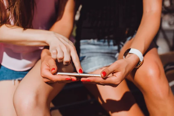 Chicas hipster utilizando teléfono inteligente al aire libre —  Fotos de Stock