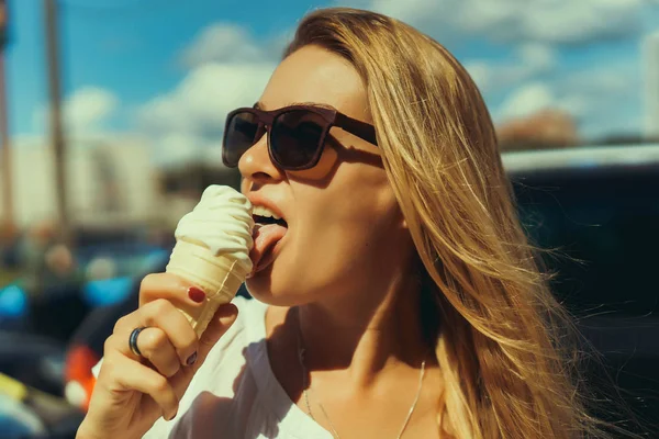 Beautiful woman eating ice cream in the street — Stock Photo, Image