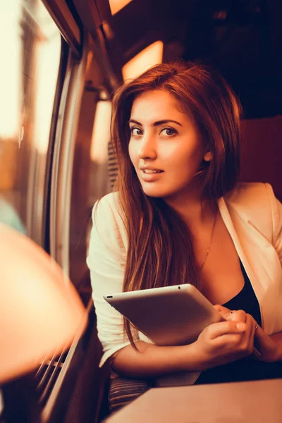 Pretty woman using tablet in train — Stock Photo, Image