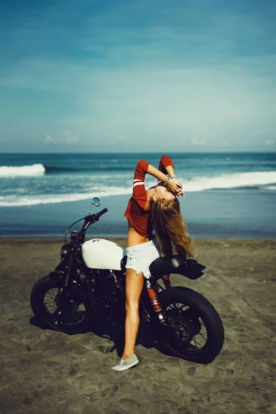 woman sitting on vintage custom motorcycle