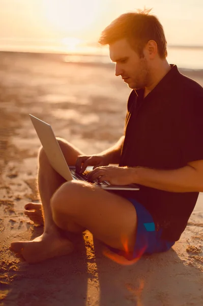 Adam sahilde laptop ile — Stok fotoğraf