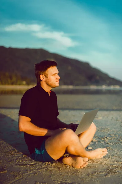 Muž s notebookem na pláži — Stock fotografie