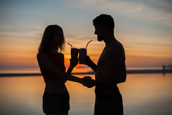 Silhouettes of couple with cocktails — Stock Photo, Image