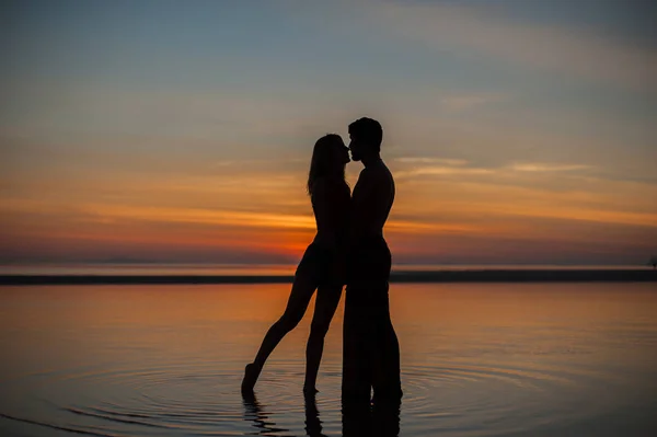 Silhouettes of couple at sunset — Stock Photo, Image