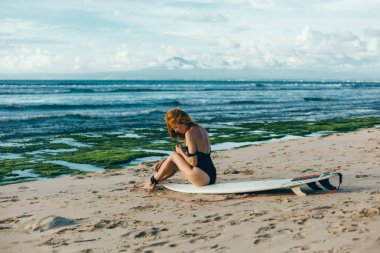 Sörfçü kız kurulu ile kumlu Sahilde yürüyüş. Sörfçü kız. Sahilde güzel ve genç birbayan. su sporları. Sağlıklı aktif yaşam tarzı. Sörf. Yaz tatili. Aşırı spor. Bali