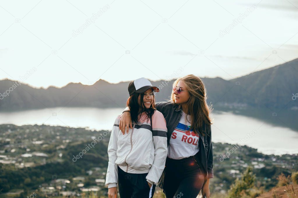 Woman traveler looking at volcano Rinjani, island Lombok. Indonesia.Young backpacker traveling along mountains, happy female walking discovering world, summer vacation concept, hand up winner, Bali