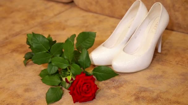 Hermosos zapatos de boda blancos con una rosa roja — Vídeo de stock