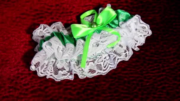 Decorated wedding garter on red background. — Stock Video