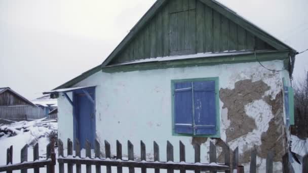 Verlaten houten huisje in winterse weergave — Stockvideo