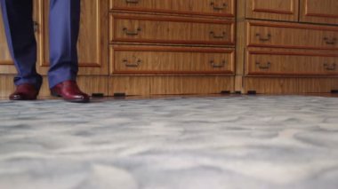 Adamın bacakları mavi kot pantolon ve kahverengi ayakkabı yapan bir adım