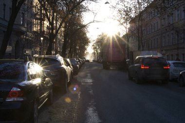 Güneşli bir gün, şehrin sokaklarında, binalar, konut, parlak güneşin parlamasını 19-20 yüzyıllarda makineleri, hareketli road, parlak güneşin parlamasını ev ve arabalar Windows'da yerleşik bir evin duvarında.