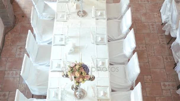 Mesas decoradas de boda. Mesa bellamente decorada con flores, velas, platos y servilletas para bodas u otro evento en el restaurante. Vista superior — Vídeos de Stock