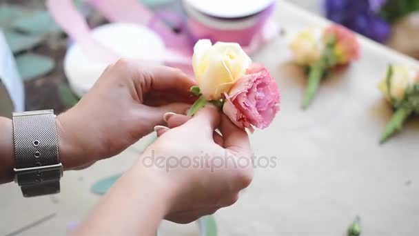 Bloemist op het werk: jonge meisje maken moderne corsages met zomer bloemen voor de ceremonie van het huwelijk — Stockvideo