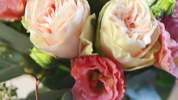 Bouquet moderne de fleurs différentes dans un vase en verre sur la table en bois 