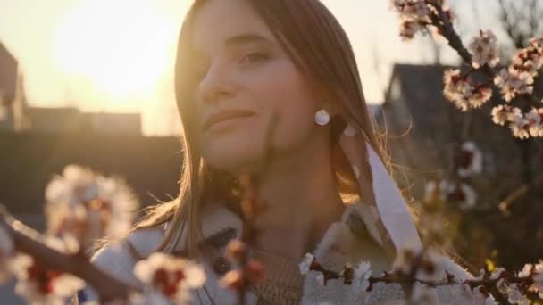 La giovane donna si toglie la maschera medica. La ragazza respira profondamente del fiore di primavera dopo la quarantena al tramonto. Ritratto di chiusura. 4k rallentatore — Video Stock