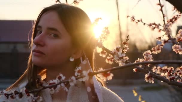 Genç kadın tıbbi maskesini çıkarıyor. Sunset 'te karantinadan sonra kız derin bir bahar çiçeği soluyor. Portreyi kapat. Yavaş çekim — Stok video