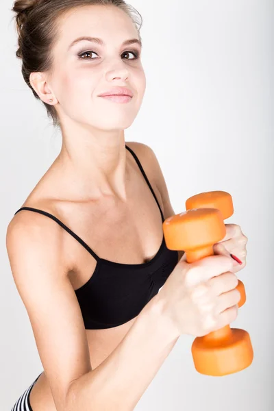 Δραστήρια αθλητική γυναίκα με βαράκια που αντλούν μυς από τους δικέφαλους. ιδέα καταλληλότητας — Φωτογραφία Αρχείου