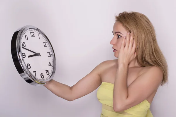 Junge schöne Frau mit großer Uhr. Zeitkonzept. Stockbild