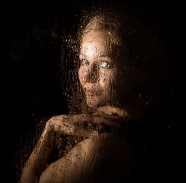 Seksi model pürüzsüz portresi, şeffaf cam arkasında poz su damlaları ile kaplı.