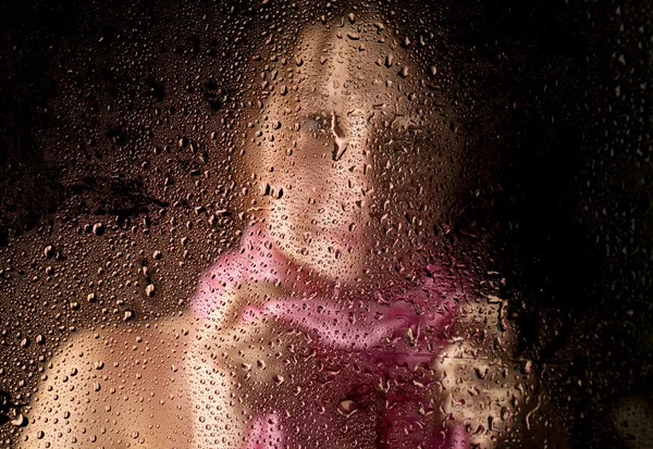 Mladá smutná žena portrét za oknem v dešti s kapkami deště na to — Stock fotografie