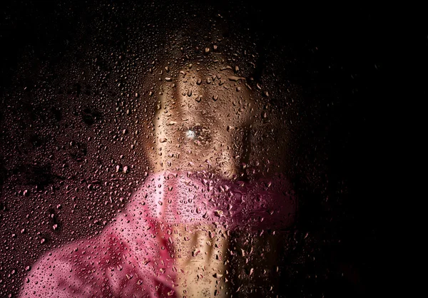 Joven mujer triste retrato detrás de la ventana en la lluvia con gotas de lluvia sobre ella —  Fotos de Stock
