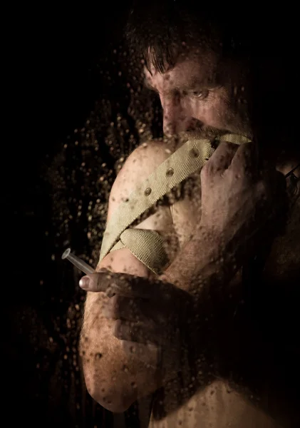 Young drug addict behind the window with drops, holding syringe — Stock Photo, Image