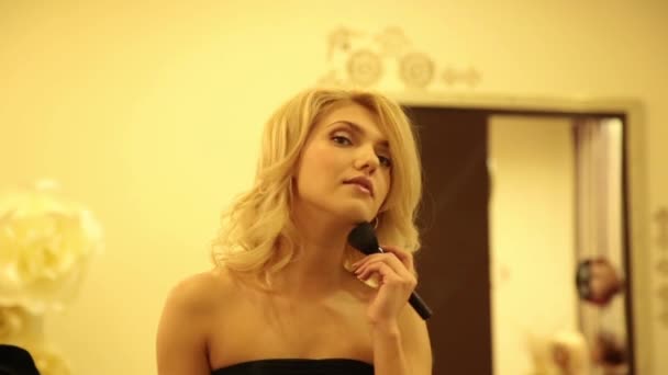 Красивая молодая женщина наносит порошок и основание для идеального макияжа на лицо — стоковое видео