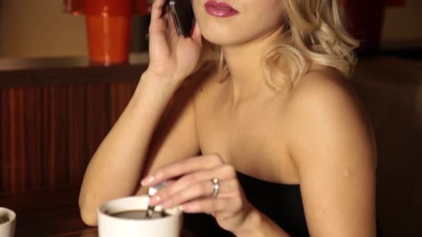 Hermosa joven feliz bebe café en la cafetería por la mañana. modelo femenino disfrutando de café expreso o té . — Vídeos de Stock