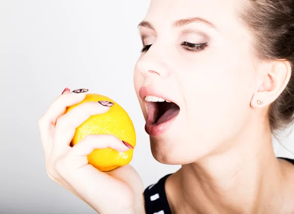 Feliz joven sonriente sosteniendo jugosos limones frescos. Alimentación saludable, frutas y verduras . — Foto de Stock
