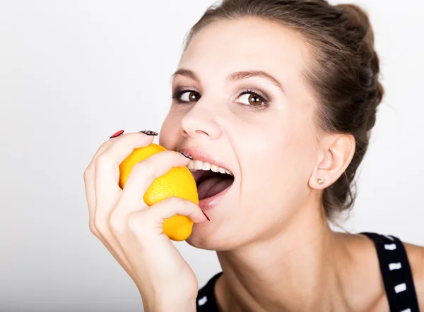 Feliz joven sonriente sosteniendo jugosos limones frescos. Alimentación saludable, frutas y verduras . — Foto de Stock